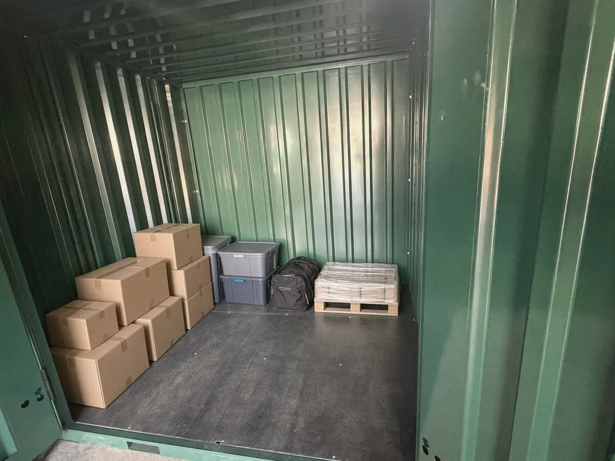 Inside a CamStorage unit with boxes, storage crates and a pallet